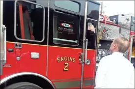  ?? / Diane Wagner ?? Rome Mayor Jamie Doss looks Monday at the black-and-red paint job on the newly delivered Pierce heavy rescue pump truck that Fire Chief Troy Brock said would replace the department’s old white-and-red color scheme.