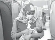  ?? — Gambar Bernama ?? BERPANTANG DI PPS: Nor Atiqah Najwa Zaniza bersama bayinya Ahmad Faiq Arsyad berusia tujuh hari berada di PPS Dewan Sivik Kampung Air Putih di Kemaman, semalam.