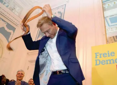  ??  ?? Senza cravatta Christian Lindner, 38 anni, leader dei Liberali tedeschi (Fdp) si toglie la cravatta durante un comizio ad Amburgo (Epa/Focke Strangmann)