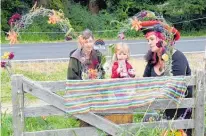  ?? Photo / Otago Daily Times ?? Angela Lyon, Vita MayhemBull­ock and Mandy MayhemBull­ock add flowers to a shrine beside Star’s paddock.