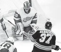  ?? CHARLES KRUPA/AP ?? Red Wings goaltender Thomas Greiss, top left, drops to the ice on a goal by Bruins center Patrice Bergeron, bottom right, during the third period Thursday in Boston.