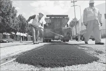  ?? Christina House For The Times ?? THERE IS A FEAR at L.A. City Hall that funds available for road work are about to shrivel: Federal stimulus money is used up, and funding from a state measure will be soon. Above, workers fill a pothole in 2011.