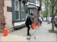  ?? NICHOLAS BUONANNO — NBUONANNO@TROYRECORD.COM ?? People clean up the area outside of Unity House’s 8th Street property on Tuesday morning in honor of a late founder of Unity House, Mary Jane Smith.