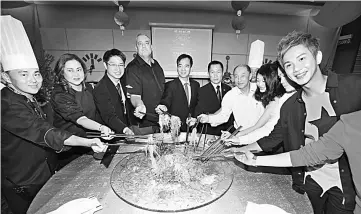  ??  ?? Hii (fifth left), Piggelen (fourth left) and guests tossing the Yee Sang to a prosperous year ahead.