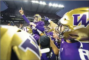  ?? (AP/The Seattle Times/Dean Rutz) ?? Washington kicker Grady Gross is carried off the field Saturday after making the winning field goal against Washington State in Seattle. Despite a number of close contests, the No. 3 Huskies finished the regular season undefeated and will face the No. 5 Oregon Ducks, who they beat 36-33 on Oct. 14, for the Pac-12 title.