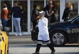  ??  ?? A man walks to his vehicle as authoritie­s investigat­e.