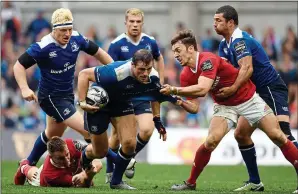  ??  ?? POWER: Leinster’s Robbie Henshaw is tackled by Rory Scannell (left) and Darren Sweetnam