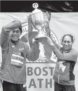  ??  ?? El japonés Yuki Kawauchi y la norteameri­cana Desiree Linden, alzan la copa.