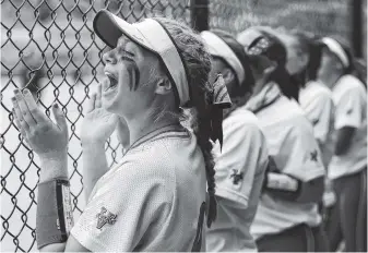  ?? STAFF PHOTO BY C.B. SCHMELTER ?? The Washington Ladyhawks’ Reese Schimmel, left, cheers from the dugout during a USA Softball 14-under girls’ fastpitch national tournament game against Tulsa (Okla.) Elite on Tuesday at The Summit of Softball.