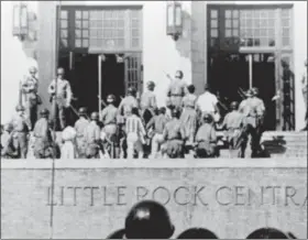  ?? FILE — THE ASSOCIATED PRESS ?? In this file photo, nine African American students enter Central High School in Little Rock, Ark., escorted by troops of the 101st Airborne Division.