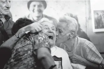  ?? ANTONIO CALANNI/AP ?? WWII reunion: Martin Adler, 97, receives a kiss from sisters Giuliana, left, and Mafalda Naldi on Monday at Bologna’s airport in Italy after a 20-hour journey from Boca Raton, Florida. Adler, then 20, is credited with saving the sisters and their brother, Bruno, as the Nazis retreated from Monterenzi­o in 1944. The kids were 3 to 6 years old when their paths crossed.