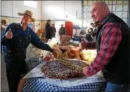  ?? LISA MITCHELL - DIGITAL FIRST MEDIA ?? Lester Miller of Kutztown and celebrity Chef Steve Mallie with the world’s largest funnel cake, measuring 30 inches across, on Nov. 28 at the Kutztown Fairground­s where funnel cake was first introduced in 1950.