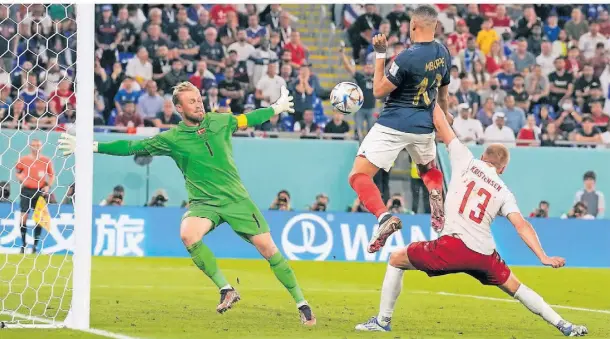  ?? FOTO: MARTIN MEISSNER/AP ?? Kylian Mbappé (M.) setzt sich in dieser Szene nicht nur gegen die dänische Abwehr durch, er überwindet auch den Torhüter und trifft zum 2:0.