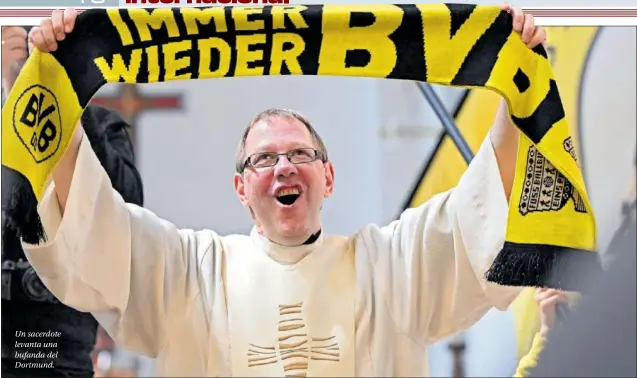  ?? ?? Un sacerdote levanta una bufanda del Dortmund.