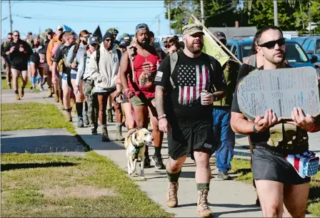  ?? PHOTOS BY DANA JENSEN/THE DAY ?? Veterans and active-duty service members walk along Route 82 in Norwich on Saturday during the Irreverent Warriors Silkies Hike. The hike, in which veterans and active duty service members wear their combat boots and “silkies,” military training shorts, is to promote mental health and suicide prevention for members of the military.