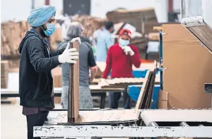  ?? NATHAN DENETTE THE CANADIAN PRESS ?? TEC Business Solutions in Mississaug­a has made mask wearing and gloves mandatory throughout the factory in December.