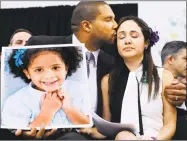  ?? Jessica Hill / Hearst Connecticu­t Media ?? Jimmy Greene kisses his wife Nelba Marquez-Greene as he holds a portrait of their daughter, Ana, a Sandy Hook victim, at a news conference in Newtown.