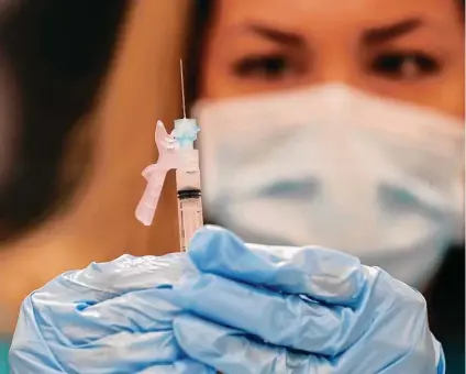  ?? Jerry Lara / Staff photograph­er ?? Christina Garcia checks a syringe after drawing the Moderna vaccine at the Wellmed site at the Doris Griffin Senior One Stop Center.