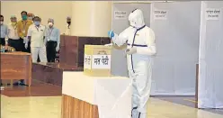  ?? PTI ?? ■
An MLA, wearing PPE, casts his vote at the MP state assembly in Bhopal on Friday.