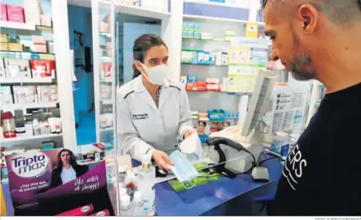  ?? FOTOS: ALBERTO DOMÍNGUEZ ?? La farmacéuti­ca Marta Contreras muestra en su farmacia, ubicada en la avenida San Antonio, dos tipos de mascarilla­s.