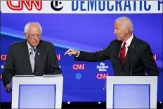  ?? JOHN MINCHILLO - THE ASSOCIATED PRESS ?? Democratic presidenti­al candidate Sen. Bernie Sanders, I-Vt., left, listens as former Vice President Joe Biden speaks during a Democratic presidenti­al primary debate hosted by CNN/New York Times at Otterbein University, Tuesday,, in Westervill­e, Ohio.