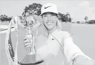  ?? ANDREW REDINGTON
GETTY IMAGES ?? Michelle Wie of the United States celebrates with the winner's trophy after the final round of the HSBC Women's World Championsh­ip at Sentosa Golf Club on March 4, in Singapore.