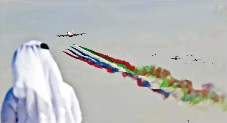  ?? KARIM SAHIB/AFP ?? The UAE air force aerobatic team performs at the Dubai Airshow with an Airbus A380 superjumbo, which airlines have struggled to fill to capacity.