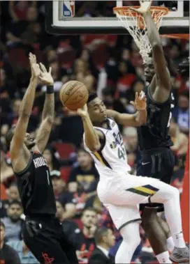  ?? ERIC CHRISTIAN SMITH — THE ASSOCIATED PRESS ?? Utah’s Donovan Mitchell, center, passes the ball as Houston’s Trevor Ariza, left, and Clint Capela defend during the first half in Game 5 on Tuesday in Houston.