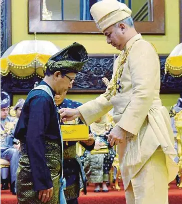  ?? PIC MUHAIZAN YAHYA ?? Sultan of Perak Sultan Nazrin Muizzuddin Shah bestowing the Darjah Paduka Mahkota Perak (DPMP), which carries the title Datuk, on ‘New Straits Times’ group editor Yushaimi Yahaya at Istana Iskandaria­h in Kuala Kangsar yesterday.