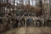  ?? UKRAINIAN PRESIDENTI­AL PRESS OFFICE VIA AP ?? Ukrainian President Volodymyr Zelenskyy, center, poses for photo with the Ukrainian soldiers in front of a Leopard 2 tank on the front line in the Kharkiv region, Ukraine, Tuesday.