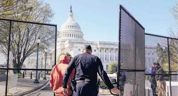  ?? AMR ALFIKY/THE NEW YORK TIMES ?? A Capitol Police officer opens a gate outside the Capitol building Saturday in Washington, near where a car rammed into a security barrier Friday, killing an 18-year veteran of the force. The driver was shot and killed.