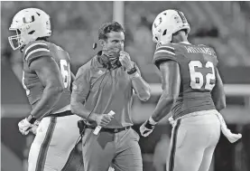  ?? [AL DIAZ/MIAMI HERALD VIA AP] ?? Miami coach Manny Diaz, center, walks on the field during the Hurricanes' 31-14 win against UAB last Thursday in Miami Gardens, Fla.