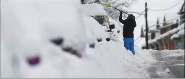  ?? BEN HASTY — READING EAGLE ?? A man clears snow from his car on Chestnut Street in West Reading on Tuesday, Feb. 1, 2021, after a nor’easter dumped heavy snow on Berks County.