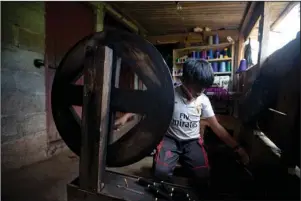  ?? The Associated Press ?? SPINNING THREAD: Juan Gabriel Vazquez spins thread at his home while schools are closed amid the new coronaviru­s pandemic in the community of Nuevo Yibeljoj, Chiapas state, Mexico, Sept. 11. Since schools closed in March, the 11-year-old is one of 12 siblings who work in the coffee fields daily instead of just the weekends, while his father helps them with school work dropped off by teachers.