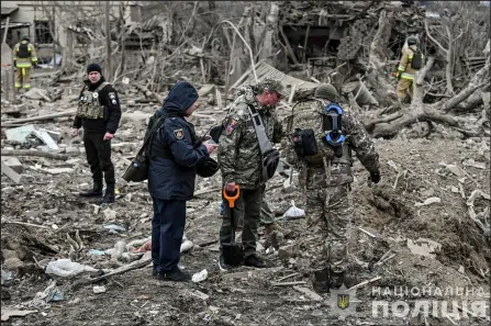  ?? — AFP photo ?? This handout photo shows National Police of Ukraine officers inspecting the site of a missile strike in Zaporozhye, amid the Russian invasion of Ukraine.