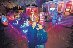  ?? CHARLES REX ARBOGAST/ASSOCIATED PRESS ?? Neighbors Beth LeFauve and Nelson Gonzalez outside their Chicago homes, with Halloween decoration­s spanning both houses.