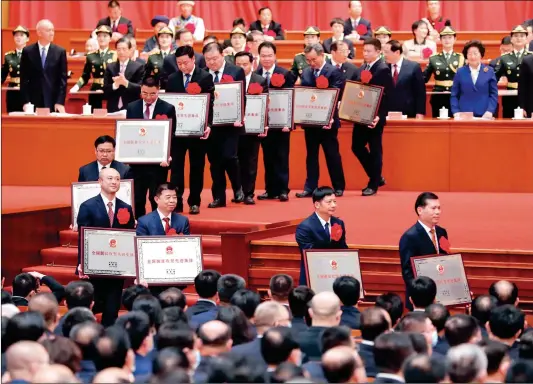  ?? Photo: Xinhua ?? Individual and collective model poverty fighters are honored during a grand gathering that is held to mark the country’s accomplish­ments in poverty alleviatio­n at the Great Hall of the People in Beijing on Thursday.