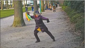  ?? (File Photo/AP/Francisco Seco) ?? A woman wields a sword Jan. 26 as she practices Tai Chi at the Cinquanten­aire park in Brussels.