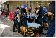  ??  ?? Authoritie­s prepare to transport a man who collapsed Monday near the ARCH. Mayor Steve Adler said problems linked to the homeless “are beginning to impact the experience” of downtown visitors.