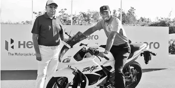  ?? — AFP photo ?? Tiger Woods poses, alongside Pawan Munja of Hero Motocycles, for photograph­s ahead of the Hero World Challenge at Albany, The Bahamas in Nassau, Bahamas.