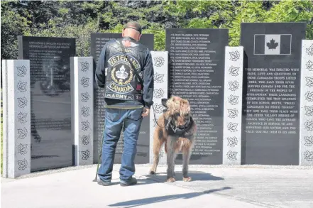  ??  ?? Reading the names on the Afghanista­n memorial at Maple Grove Education Centre following the Aug. 31 Wharf Rat Rally memorial ride and ceremony.