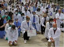  ?? RICK BOWMER THE ASSOCIATED PRESS ?? Health-care workers and medical students kneel at the University of Utah in Salt Lake City on Friday.