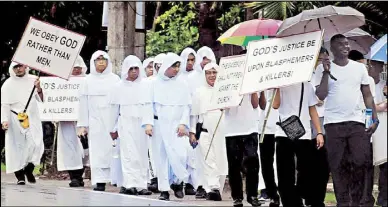  ?? CESAR RAMIREZ ?? Seminarian­s and members of the clergy carry slogans in a penitentia­l pilgrimage from San Jacinto Church in San Jacinto, Pangasinan to the Minor Basilica of Our Lady of Manaoag yesterday during a ‘Day of Reparation’ over the murder of Fr. Richmond Nilo.