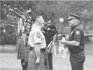  ?? PHOTOS: JEAN LEVAC/OTTAWA CITIZEN ?? Police Chief Charles Bordeleau talks to the Ottawa Police Service Pipe Band at Vincent Massey Park on Wednesday as the musicians get ready to leave for the World Pipe Band Championsh­ips in Scotland.