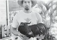  ?? — Gambar Bernama ?? AYAM BAKA: Mohamad Zulfadli bersama ayam baka Sumatera yang berharga hampir RM15,000 sempena Ekspo Johor Berkemajua­n yang berlangsun­g di Iskandar Puteri, semalam.
