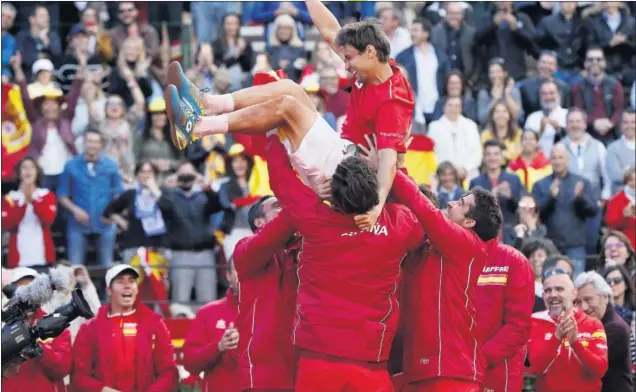  ??  ?? EL HEROE. David Ferrer, uno de los puntales del equipo desde su debut en 2006, fue manteado por sus compañeros después de abrochar el quinto punto. La locura en la plaza.