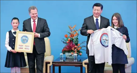  ?? FENG YONGBIN / CHINA DAILY ?? President Xi Jinping and Finnish President Sauli Niinisto, attending the inaugurati­on of the 2019 China-Finland Year of Winter Sports, are given items with the year’s logo by children from each country at the Great Hall of the People in Beijing on Monday.