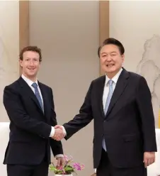  ?? — AFP photo ?? Yoon (right) shaking hands with Zuckerberg during their meeting at Yoon’s office in Seoul.