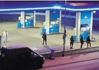  ?? CHRISTIAN SCHULZ THE ASSOCIATED PRESS ?? Police officers secure a gas station in Idar-Oberstein, Germany, on Sunday after a worker was shot dead.