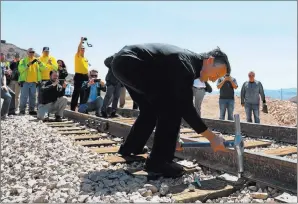  ?? Andrea Cornejo ?? Las Vegas Review-journal @dreacornej­o Nevada Gov. Brian Sandoval drives the final spike into a rail line during an event hosted by the Nevada State Railroad Museum in Boulder City on Friday.